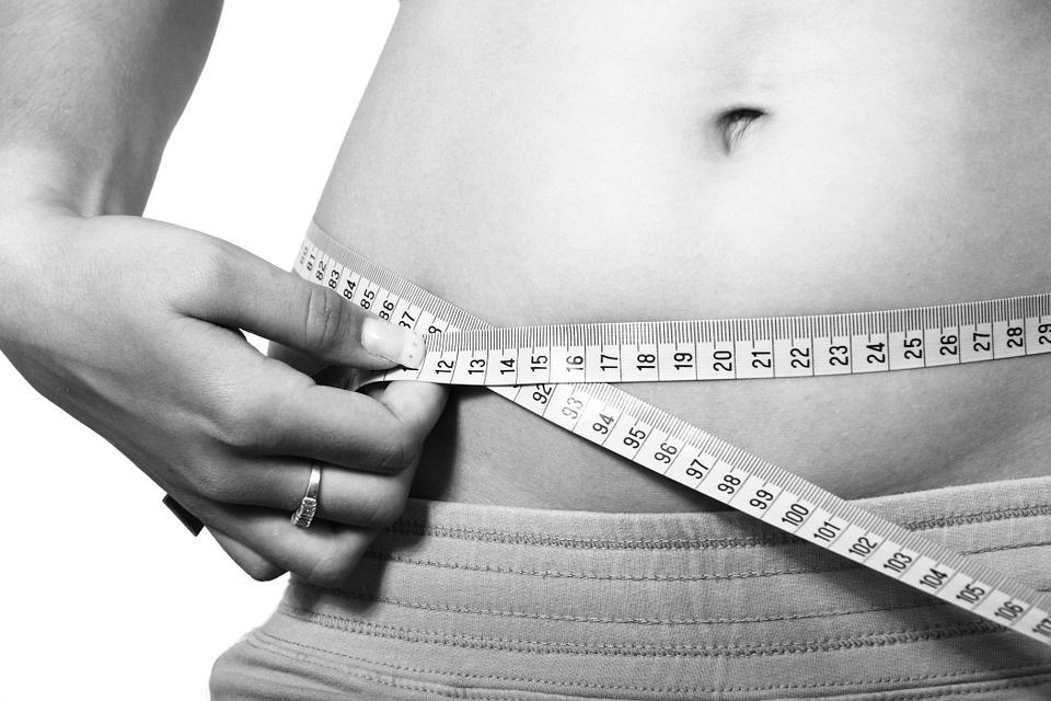 Woman measuring her waistline
